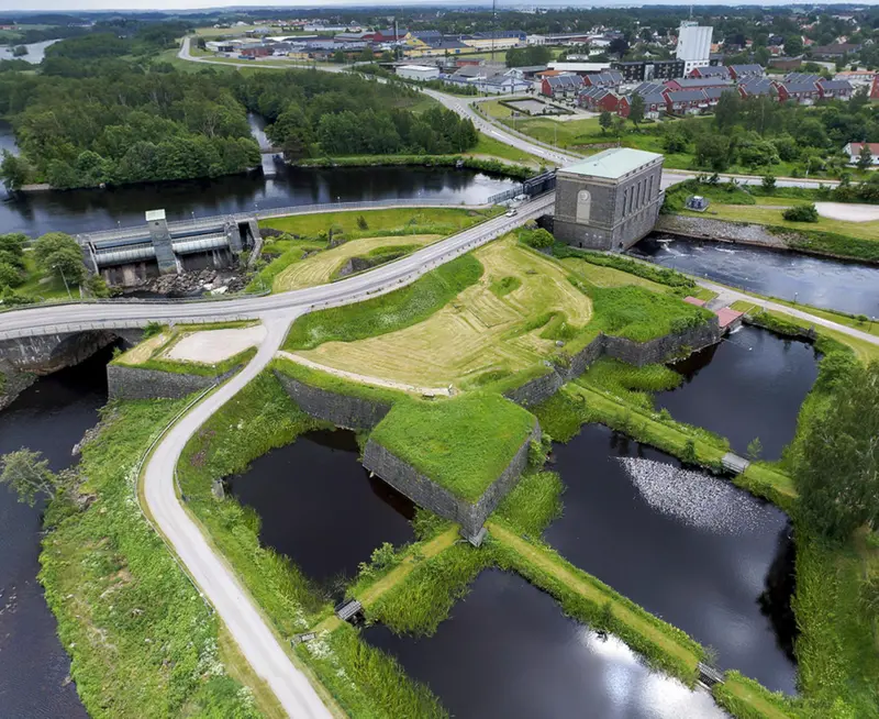 Flygbild över Lagaholms slottsruin. Vid ruinen syns ån Lagan och ett kraftverk. 